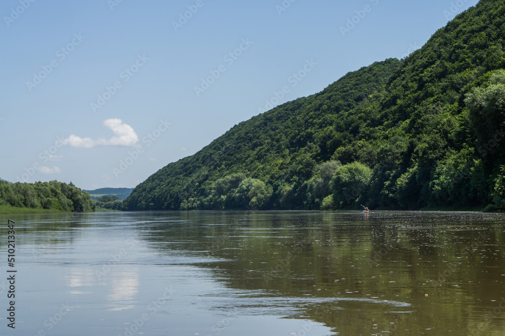 Dniester. Ivano-Frankivsk region. June 20, 2019; A group of tourists floating in a canoe on the river.