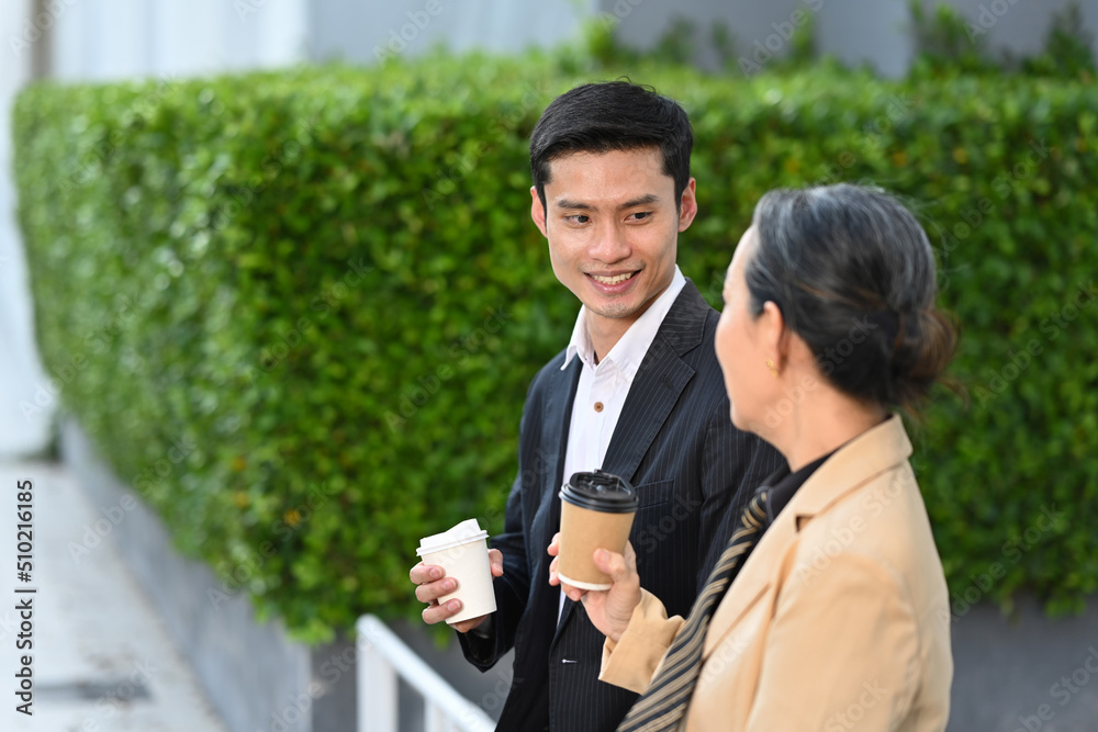 Businesspeople sitting outside modern office building and talking each other Businesspeople sitting outside modern office building and talking each other