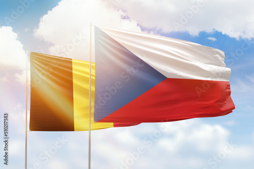 Sunny blue sky and flags of czechia and belgium