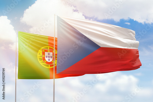 Sunny blue sky and flags of czechia and portugal