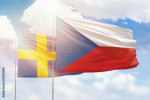 Sunny blue sky and flags of czechia and sweden
