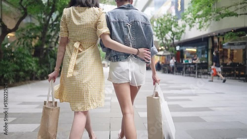 Young Asian femlae lgbtq couple spending time together window shopping along the shopping mall walking way during the day, pride month, freedom love relationships, lesbian same love, same sex marriage photo