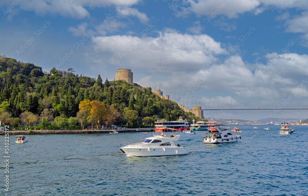Istanbul, Turkey - September .30. 2021 : In front of the Rumeli Fortress on the European side, people tour the Bosphorus with boats