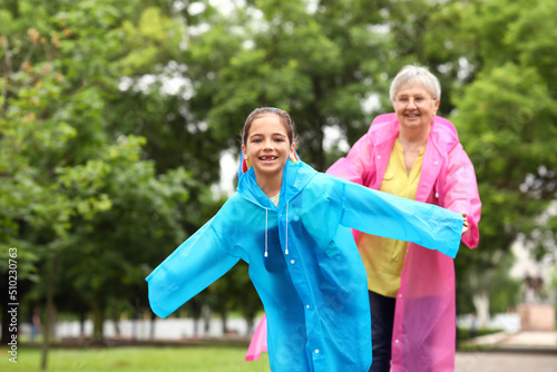 Little girl in raincoats ha...