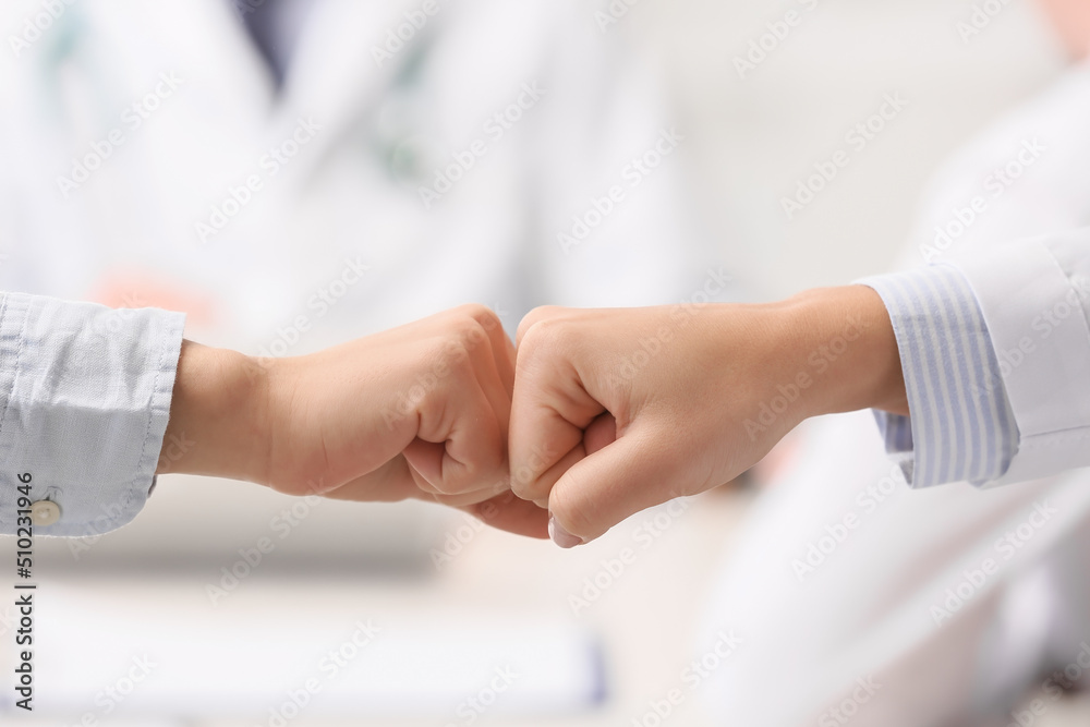Doctor and patient bumping fists in clinic Doctor and patient bumping fists in clinic
