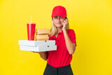 Delivery Uruguayan woman holding fast food isolated on yellow background frustrated and covering ears