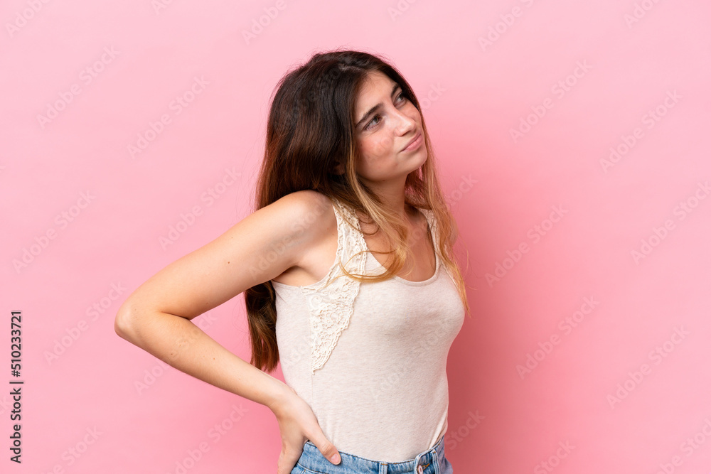 Young caucasian woman isolated on pink background suffering from backache for having made an effort Young caucasian woman isolated on pink background suffering from backache for having made an effort