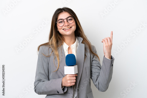 Young caucasian TV presenter woman isolated on white background showing and lifting a finger in sign of the best