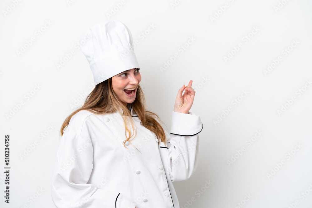 Young caucasian chef woman isolated on white background pointing finger to the side and presenting a product Young caucasian chef woman isolated on white background pointing finger to the side and presenting a product