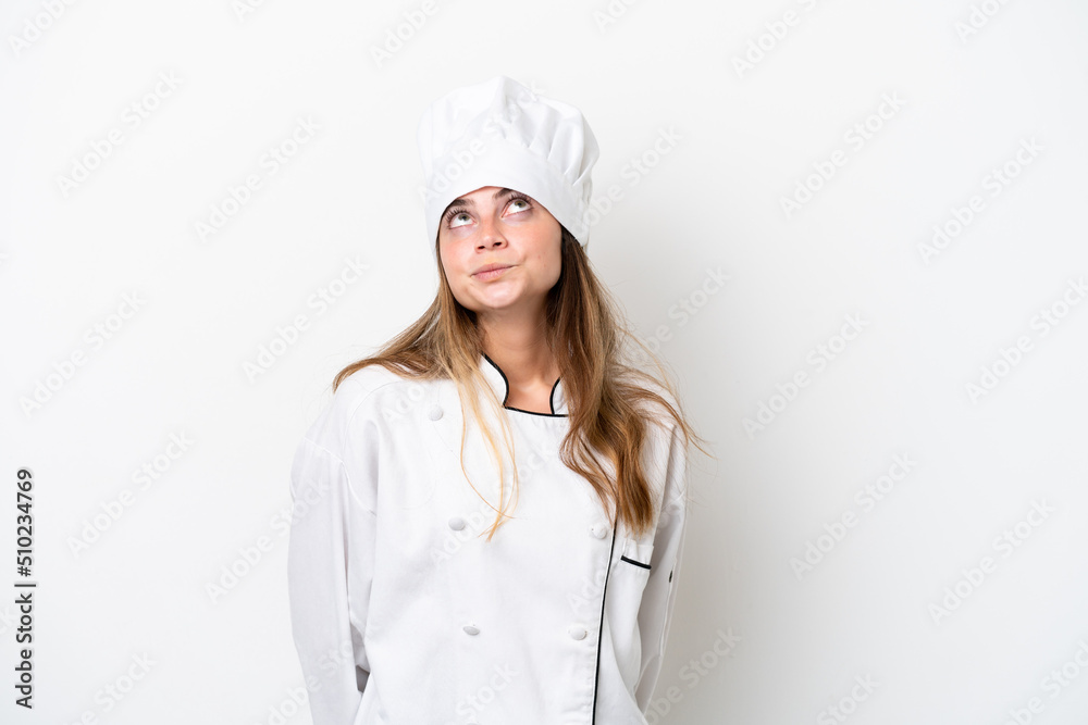 Young caucasian chef woman isolated on white background and looking up Young caucasian chef woman isolated on white background and looking up
