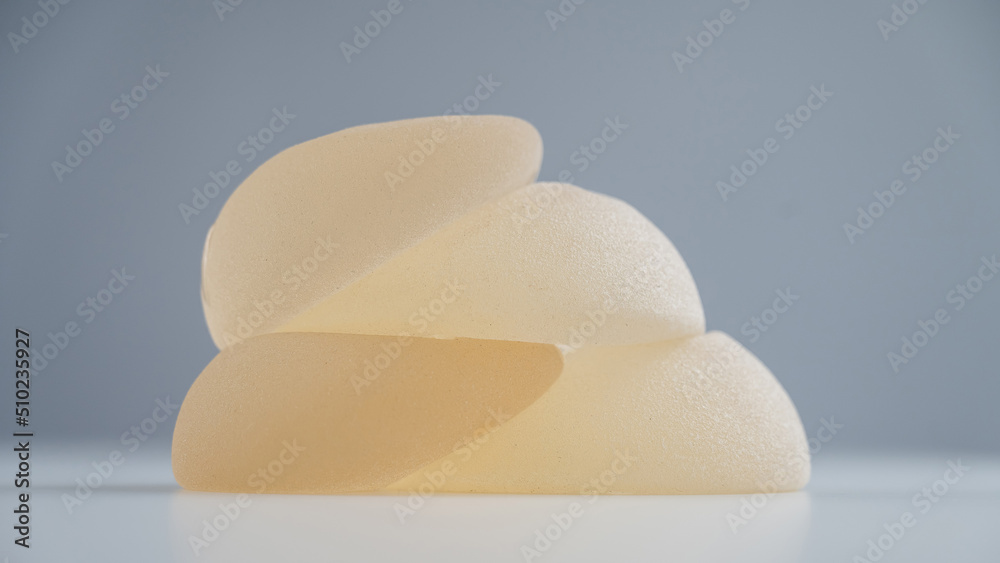 A pile of breast implants on a white background. A pile of breast implants on a white background.