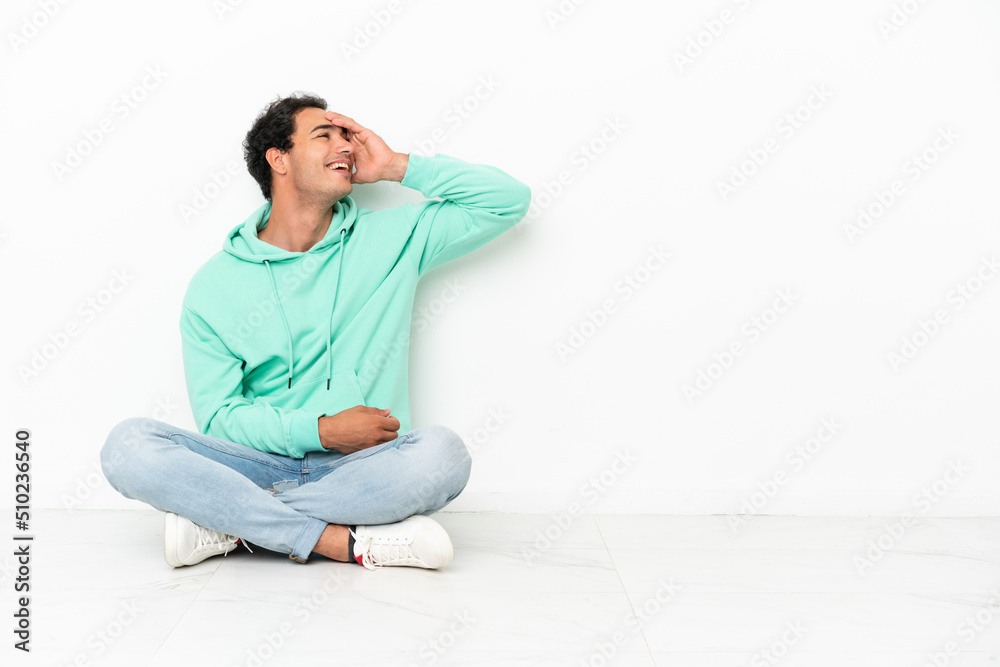 Caucasian handsome man sitting on the floor has realized something and intending the solution Caucasian handsome man sitting on the floor has realized something and intending the solution