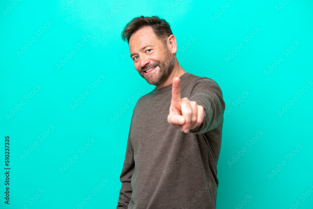 Middle age caucasian man isolated on blue background showing and lifting a finger Middle age caucasian man isolated on blue background showing and lifting a finger