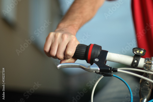 a hand holding a handlebars of a bicycle