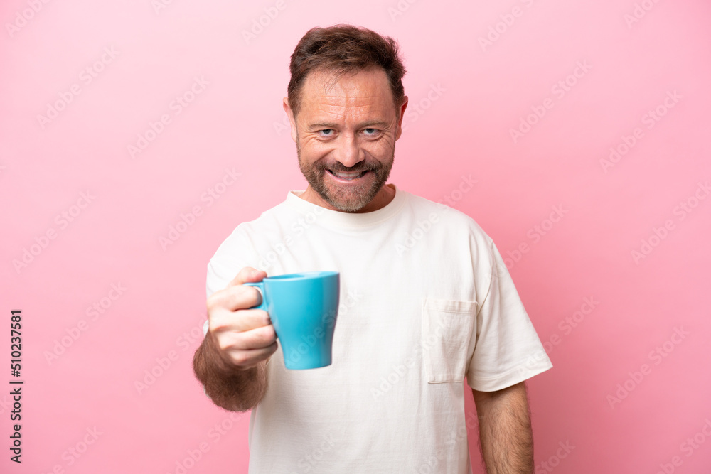 Middle age caucasian man holding cup of coffee isolated on pink background with happy expression Middle age caucasian man holding cup of coffee isolated on pink background with happy expression