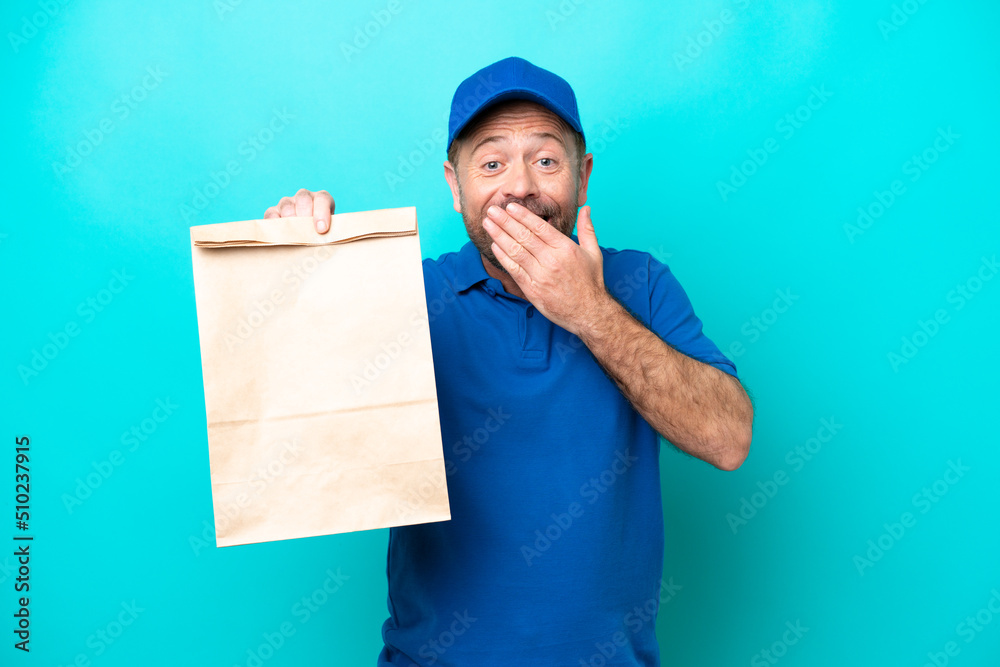 Middle age man taking a bag of takeaway food isolated on blue background happy and smiling covering mouth with hand Middle age man taking a bag of takeaway food isolated on blue background happy and smiling covering mouth with hand