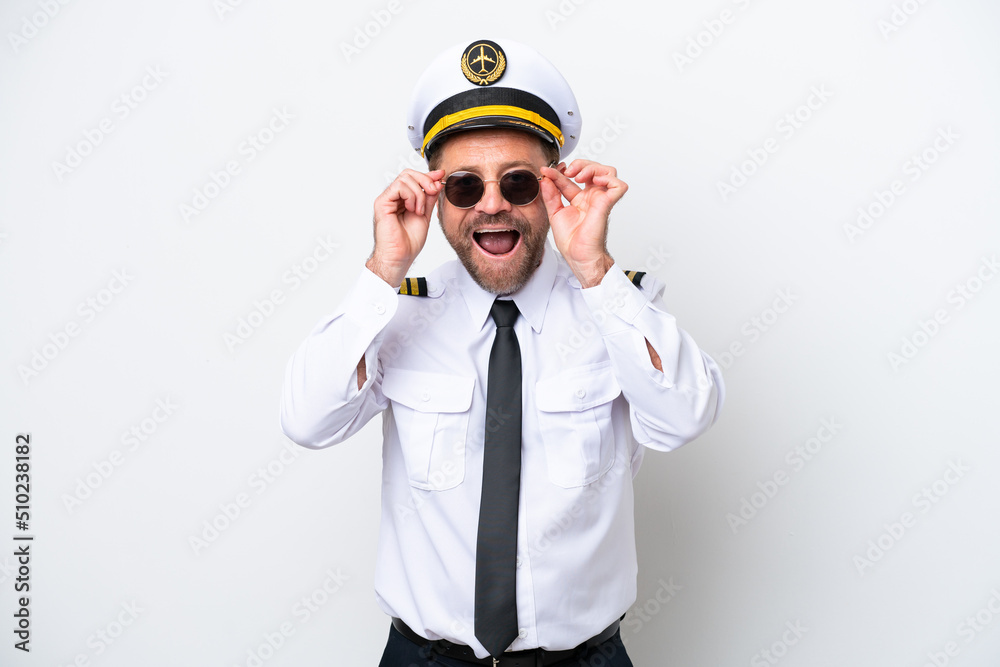 Airplane middle age pilot isolated on white background with glasses and surprised Airplane middle age pilot isolated on white background with glasses and surprised
