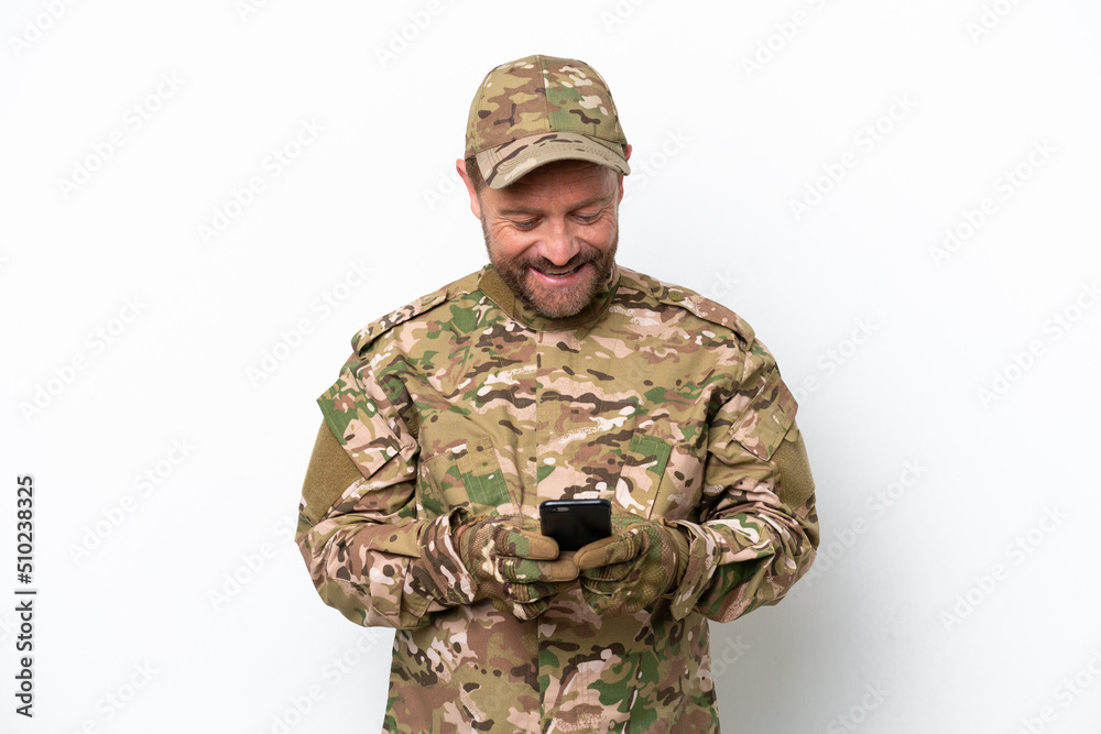 Military man isolated on white background sending a message with the mobile Military man isolated on white background sending a message with the mobile