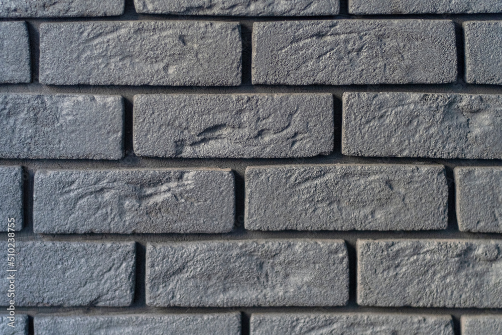 Wall is made of gray bricks. Abstract background. Rough textured surface. Grunge or loft style. Wall is made of gray bricks. Abstract background. Rough textured surface. Grunge or loft style.