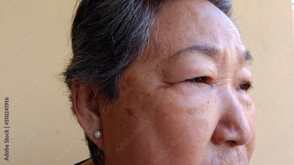 Obraz premium An old woman has wrinkles on her face.