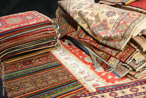pile of Persian and other rugs for sale in the shop specializing in home furnishings