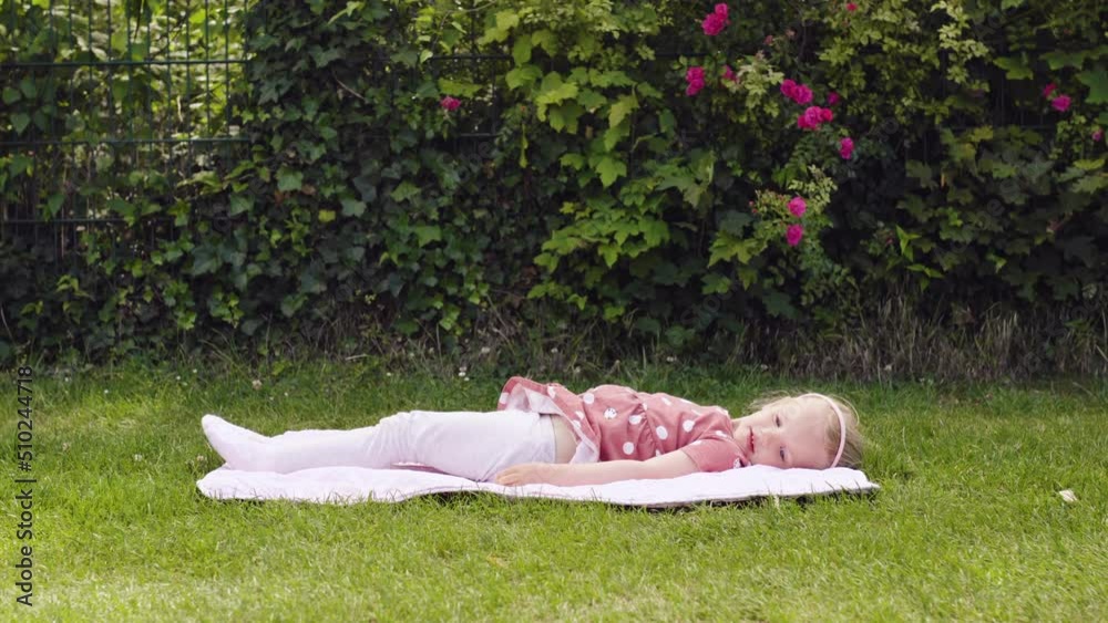 Little Girl Doing Yoga Exercises In park. The baby does exercises on the grass. The right sporting childhood.  little girl doing exercises in the park. 