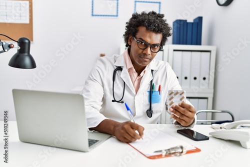 Young south east man wearing doctor uniform holding pills at clinic