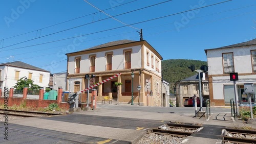 Railroad level crossing at the entrance of the San Clodio - Quiroga train station closing while the chime sounds, the semi-barriers lower and the 