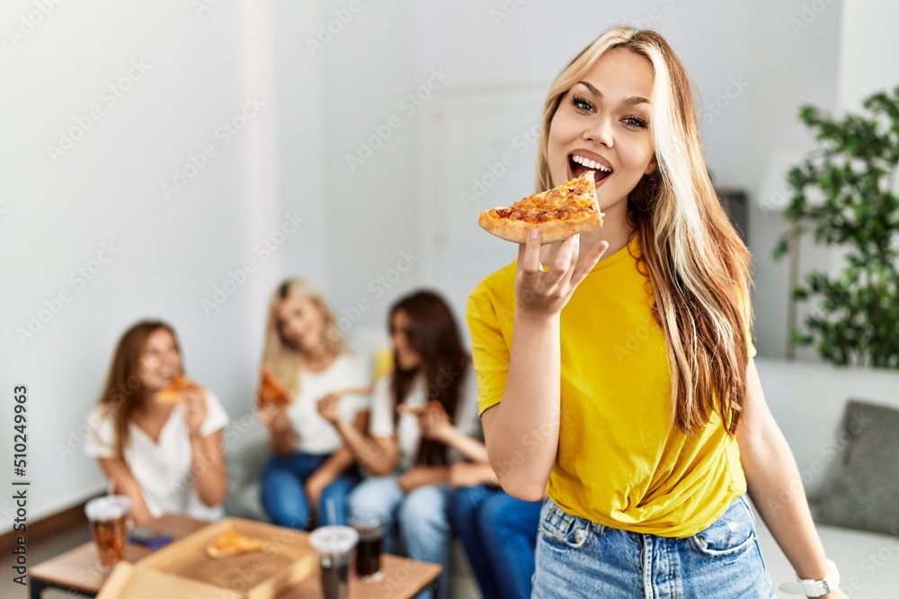 Group of young woman friends smiling happy eating pizza at home. Group of young woman friends smiling happy eating pizza at home.