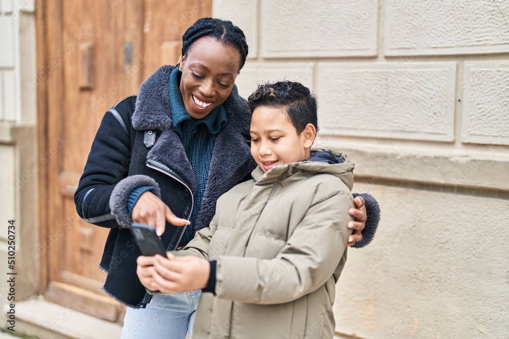 African american mother and son smiling confident using smartphone at street African american mother and son smiling confident using smartphone at street