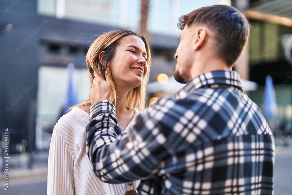 Young man and woman couple hugging each other standing at street Young man and woman couple hugging each other standing at street