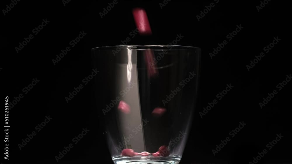 red beans fall into a glass on a black background red beans fall into a glass on a black background