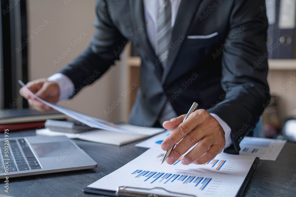 Accountant man hand press on a calculator for make financial report or company's profit monthly at desk, bookkeeper job and work from home concept