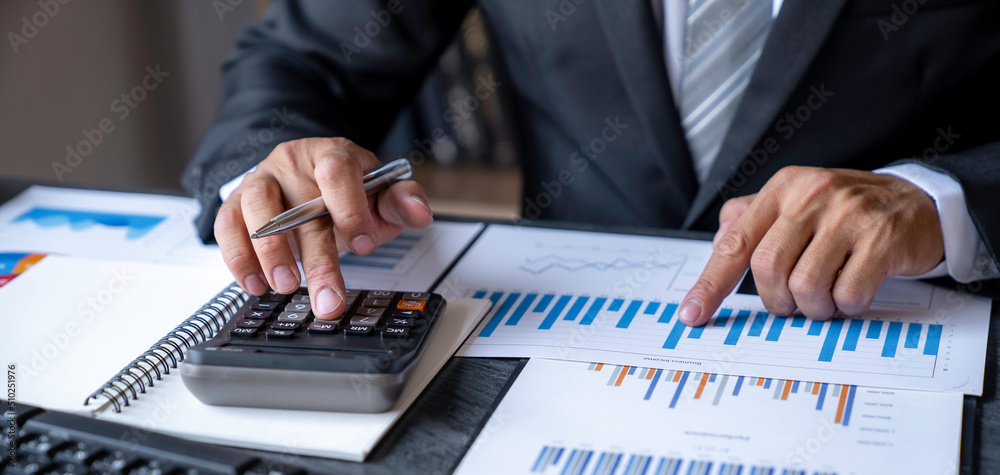 Businessman accountant using calculator and laptop for calculating finance on desk office. business financial accounting concept. Businessman accountant using calculator and laptop for calculating finance on desk office. business financial accounting concept.