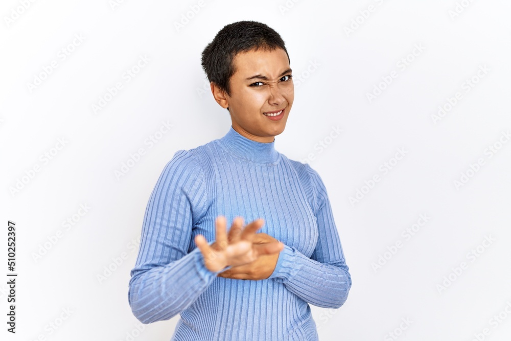 Young hispanic woman with short hair standing over isolated background disgusted expression, displeased and fearful doing disgust face because aversion reaction. with hands raised Young hispanic woman with short hair standing over isolated background disgusted expression, displeased and fearful doing disgust face because aversion reaction. with hands raised