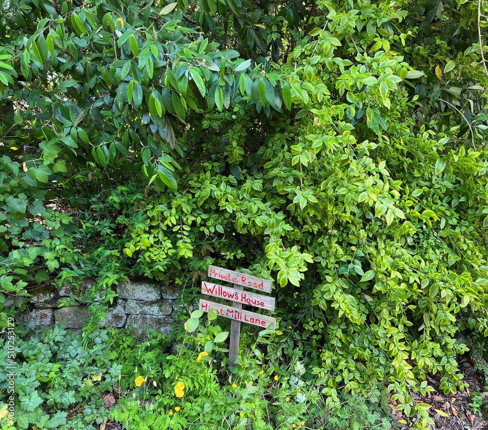 Small wooden sign, amidst green foliage in, Hirst Wood, Shipley, UK Small wooden sign, amidst green foliage in, Hirst Wood, Shipley, UK