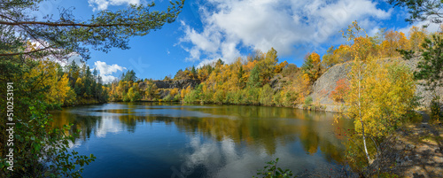 flooded quarry surrounded by trees in autumn photo