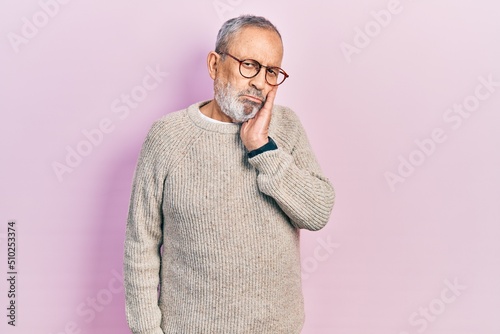 Handsome senior man with beard wearing casual sweater and glasses thinking looking tired and bored with depression problems with crossed arms.