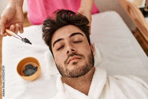 Man reciving facial treatment at beauty center. photo