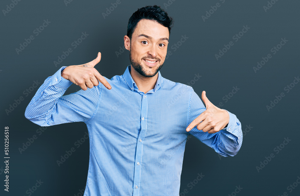 Hispanic man with beard wearing casual business shirt looking confident with smile on face, pointing oneself with fingers proud and happy. Hispanic man with beard wearing casual business shirt looking confident with smile on face, pointing oneself with fingers proud and happy.