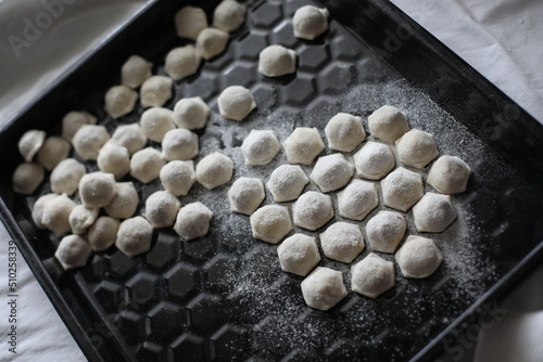 raw frozen dumplings on a black dish