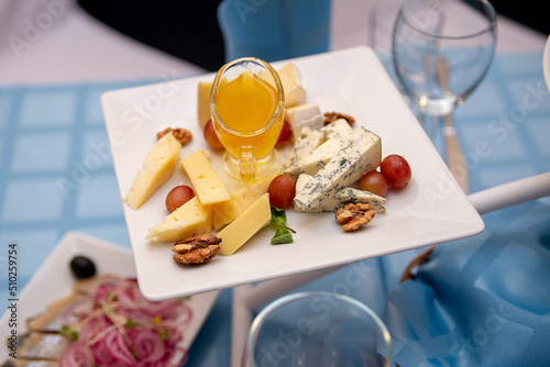 plates of cold cheese appetizers on a served table. wedding banquet celebration