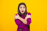 Surprised emotions of young teenager girl. Teenager child girl with shocked facial expression. Surprised face expression, isolated on yellow background. Funny surprise.