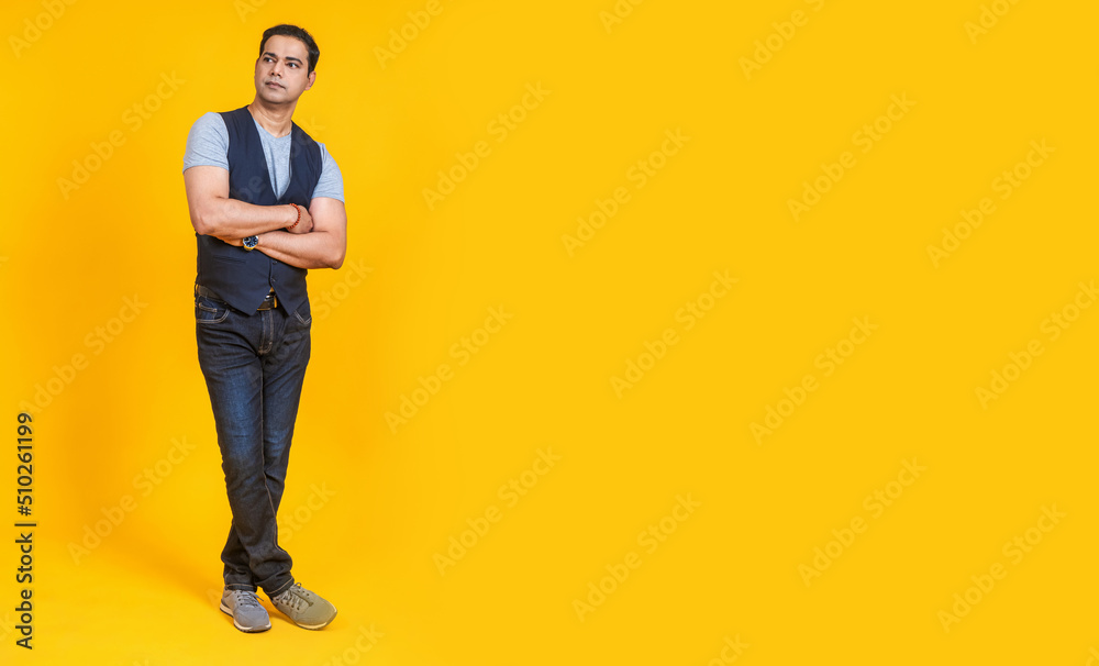 The guy is in a thoughtful position. A man on a yellow background. The guy is in the vest. Place for the inscription with a person. The guy is in a thoughtful position. A man on a yellow background. The guy is in the vest. Place for the inscription with a person.