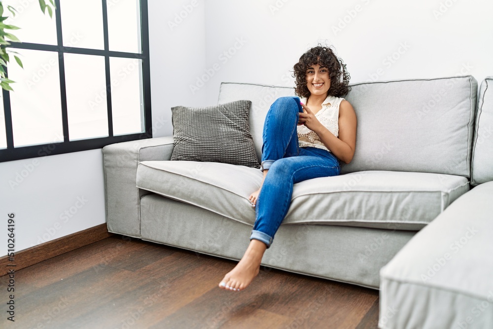 Young middle east woman smiling confident listening to music at home