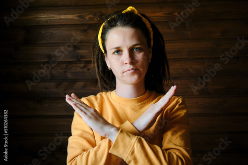 No way, absolutely not. Sign Language. Portrait of determined European young woman with dreadlocks depicting X sign with crossed arms meaning stop, this is the end. Concept of hard of hearing people.