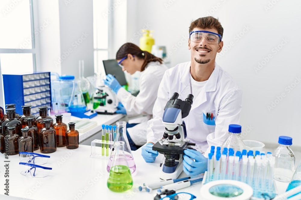 Man and woman partners wearing scientist uniform working at laboratory Man and woman partners wearing scientist uniform working at laboratory