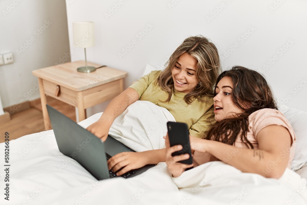 Young couple using smartphone and watching movie at bedroom Young couple using smartphone and watching movie at bedroom