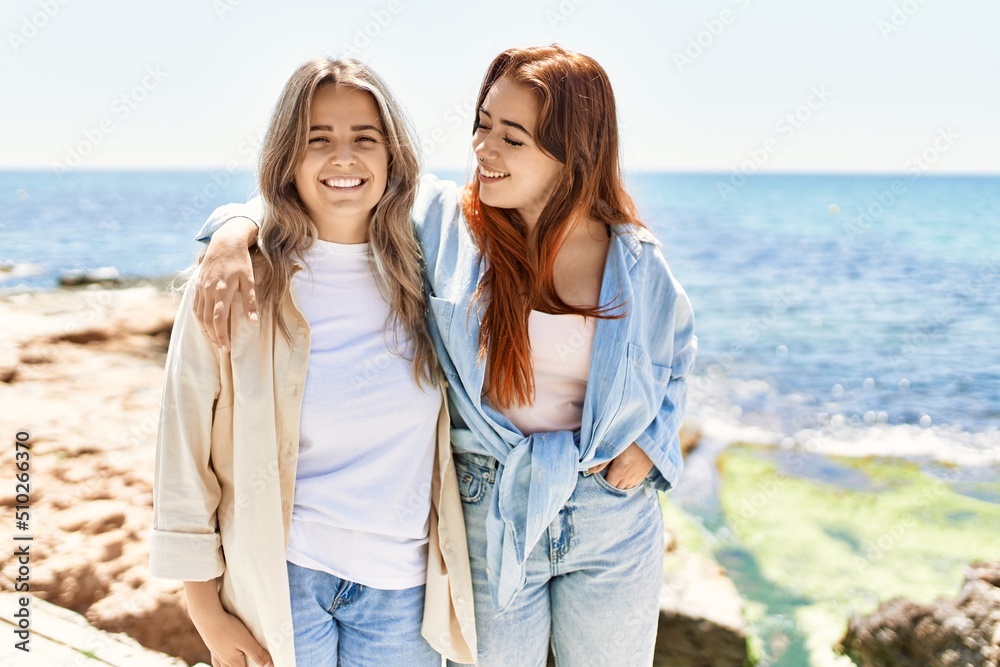 Young lesbian couple of two women in love at the beach. Beautiful women together at the beach in a romantic relationship Young lesbian couple of two women in love at the beach. Beautiful women together at the beach in a romantic relationship
