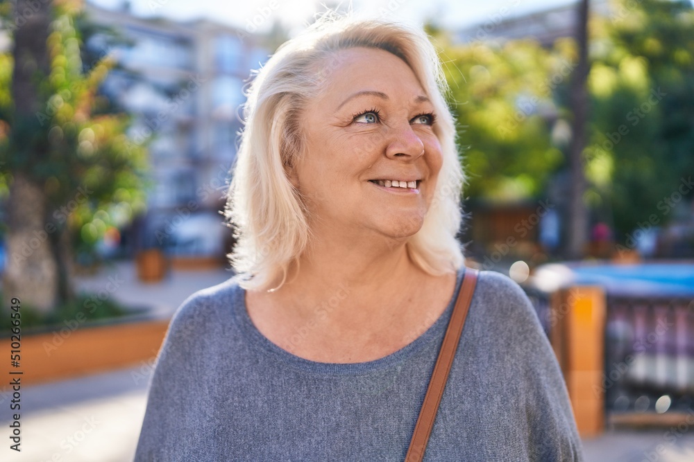 Middle age blonde woman smiling confident standing at park Middle age blonde woman smiling confident standing at park